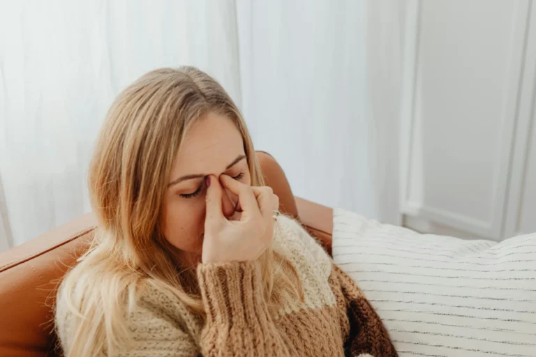 Anxious woman massaging chest while practicing stress-relief breathing exercises