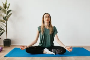 Woman doing relaxing yoga poses to relieve menstrual cramps at home.